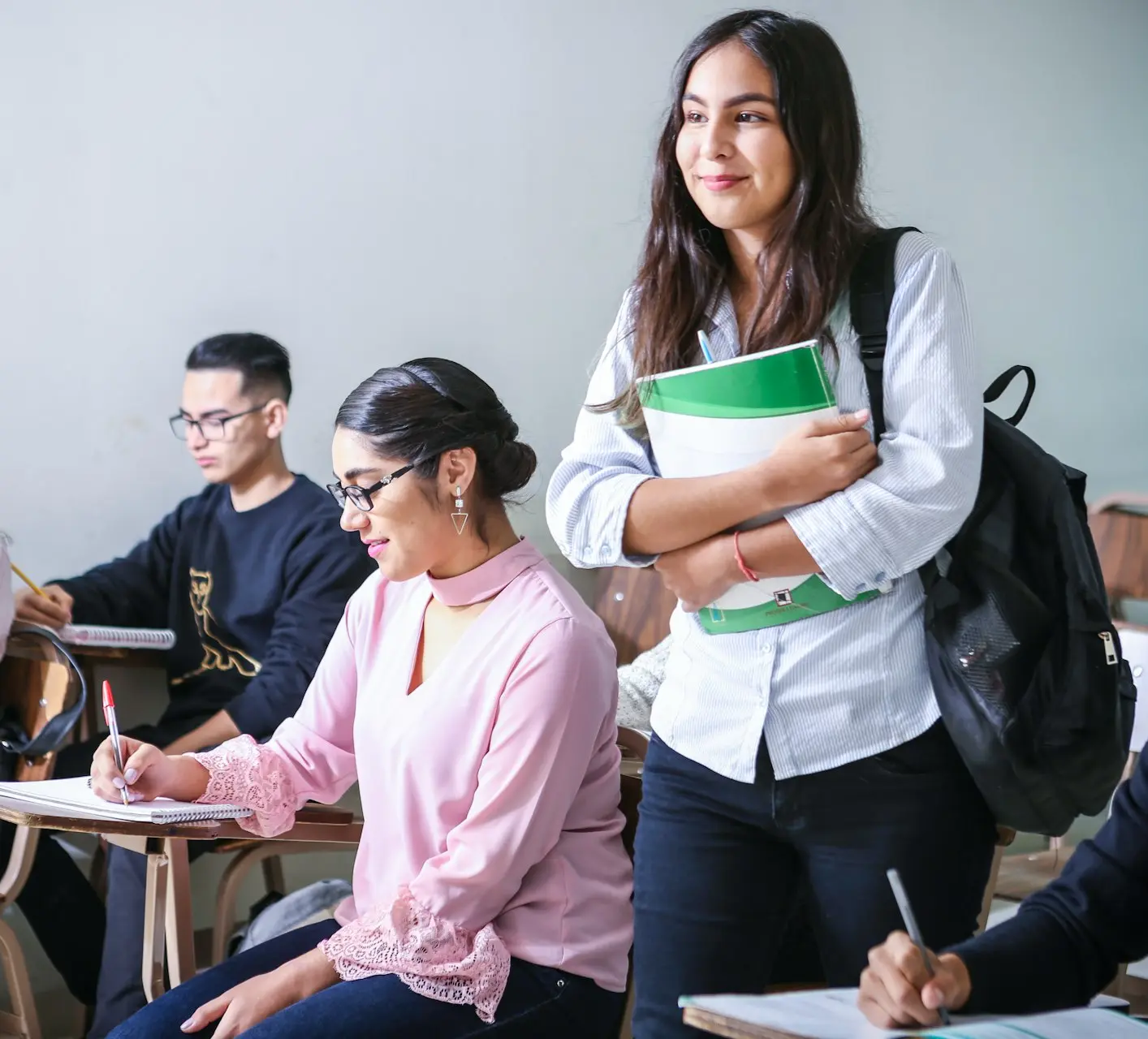 woman carrying white and green textbook